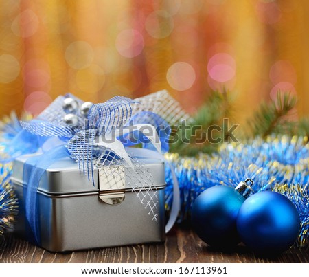 Closeup of christmas balls and gift box on abstract background