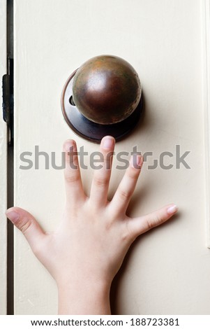 Kid\'s hand reaching up for the door knob to open it