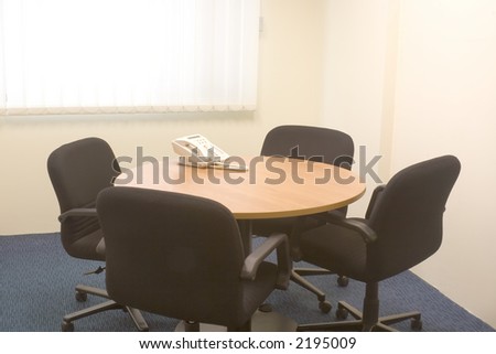 Small meeting room with table, chairs and telephone