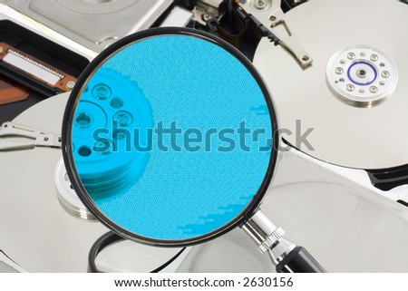 Magnifying glass over a opened hard drive depicting computer forensic