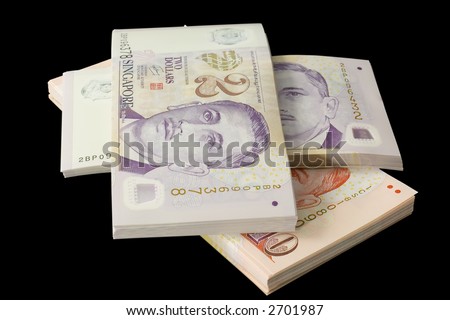 Stacks of Singapore currency isolated on black background