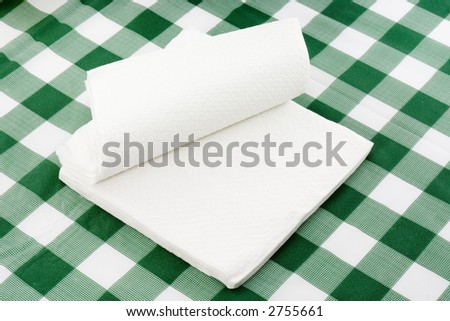 Stack of paper napkins on top of a tablecloth