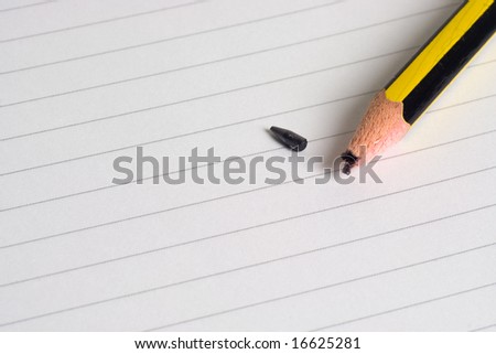 Pencil with a broken tip on a writing pad