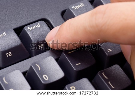 Closeup of a finger pressing SEND button on a keyboard