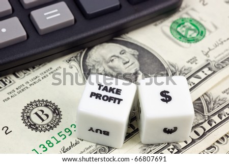 US currency with calculator and dice showing TAKE PROFIT