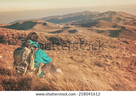 Woman hiking in beautiful nature, recreation and healthy lifestyle outdoors in wild. Hiker backpacker sitting on mountain top.