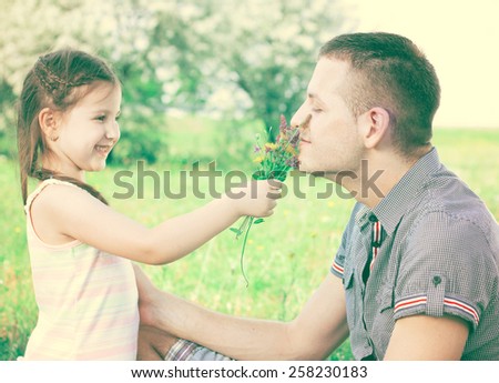 Little girl with flowers in hand and uncle smiling and enjoy in beautiful day
