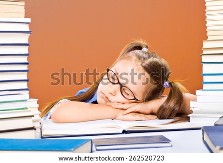 Little scholar girl with pile of books sleeping and tired