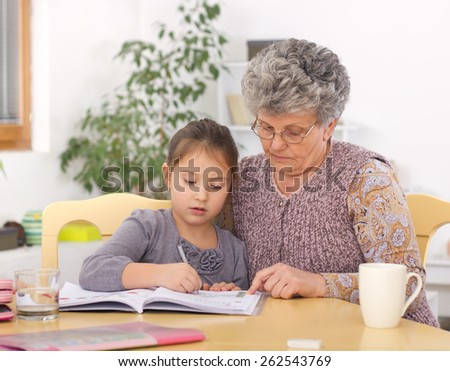 Grandmother and daughter writing and learning homework at domestic room