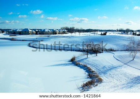 Curvy landscape on the snow covered golf course and pond. More with keyword Group1.