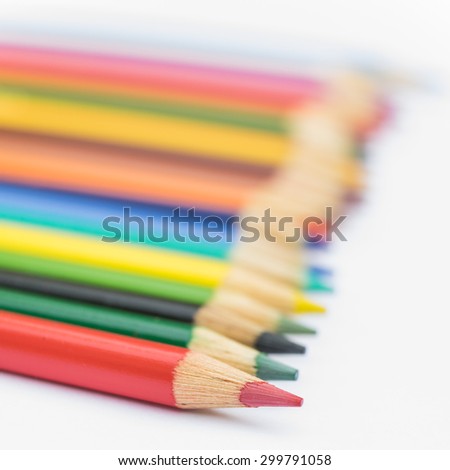 Colored pencils lined up on white background