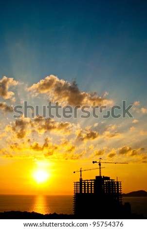 Ray on black cloud when sun set back tower crane