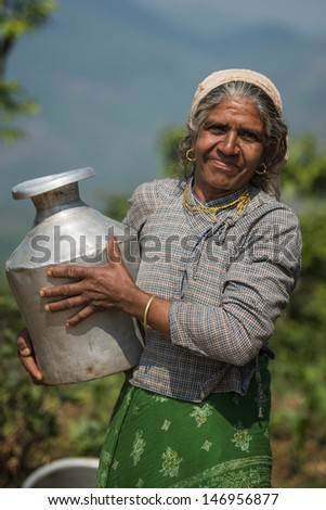 POKHARA, NEPAL - APRIL 28: Nepalese woman in national clothes with jug in Pokhara, Nepal on April 28, 2013.  Due to its proximity to the Annapurna mountain range, Pokhara is also a base for trekkers.