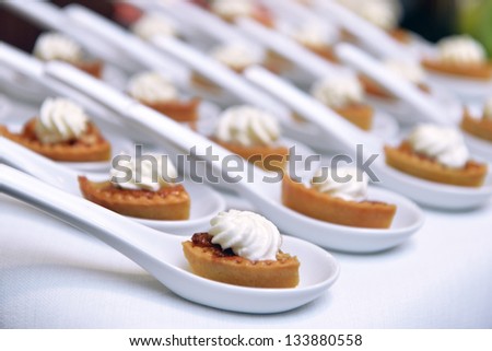biscuits with cream and jam in a cocktail party spoons
