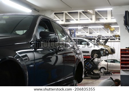 car in garage with special equipment prepared for repair