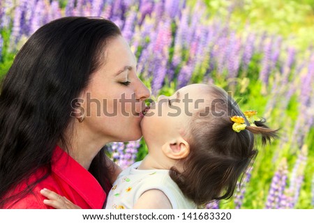 young mother kissing her little daughter