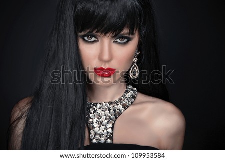 Beautiful Brunette Girl with red lips. Healthy Long Hair isolated on black