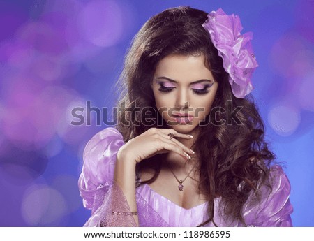 Beautiful woman with curly hair and evening make-up. Jewelry and Beauty. Fashion art photo