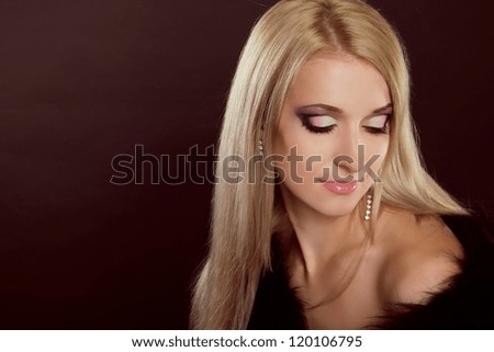 Beautiful woman with blond hair and evening make-up. Jewelry and Beauty. Fashion art photo