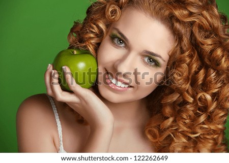 Young happy smiling beautiful woman with apple. Curly hair