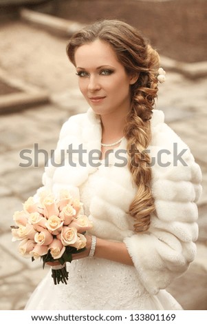 Outdoors portrait of Beautiful bride with bouquet of flowers