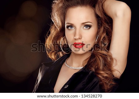 Portrait of Beautiful woman with curly hair and evening make-up. Jewelry and Beauty. Fashion art photo