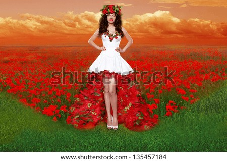 Outdoors portrait of Beautiful young woman wearing in red rose dress opened flowers field. Fashion Art Photo. Traditional Ukraine costume