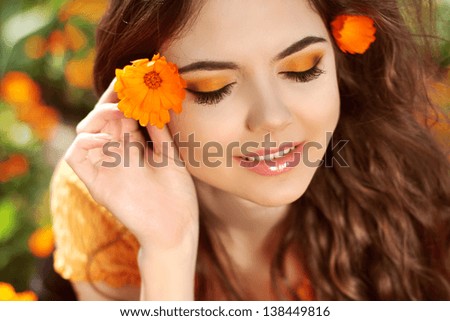 Beauty Model Woman Face. Smiling woman with eye-shadows over flowers, outdoors portrait