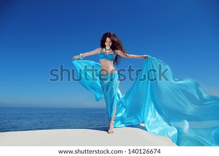 Enjoyment. Beautiful girl enjoying the freshness.  Free happy woman with blowing tissue over blue sky