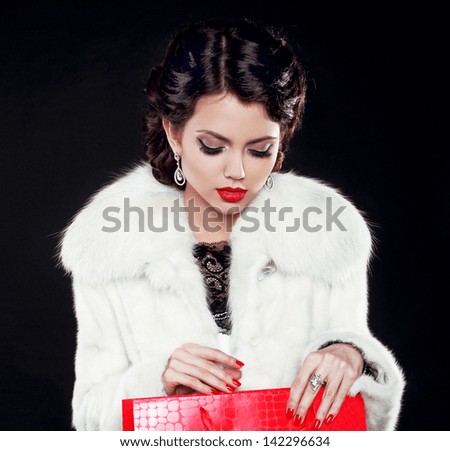 Fashion model woman in fur coat open shopping bag. Isolated on black background. Retro girl.