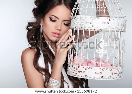 Tender Woman holding vintage bird cage isolated on grey background