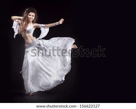 Beauty Girl belly dancer in white suit oriental dance in motion isolated on black background