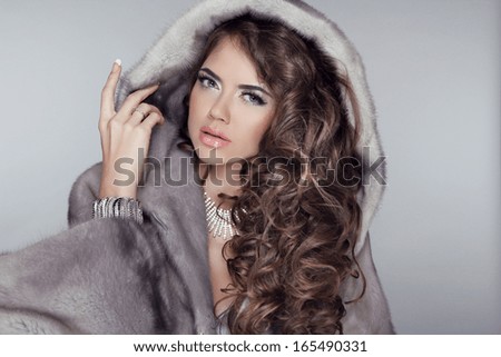 Long hair. Luxury beautiful  wearing in mink fur coat with long hair styling isolated on grey background. Fashion winter woman model posing.