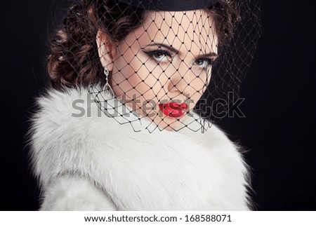 Beauty portrait of passionate elegant woman with hot red lips, wearing in white fur coat Isolated on black background.