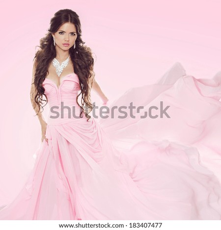Beautiful brunette girl wearing in wedding dress isolated on pink background
