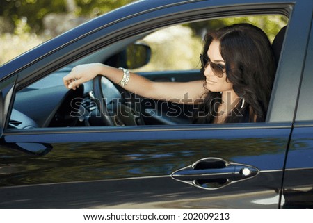 Brunette woman sitting in car, beautiful sexy female driver