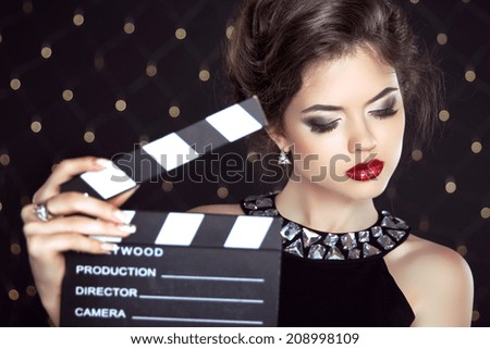 Fashion woman with sexy red lips holding cinema clap. Super star model shot