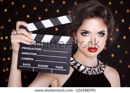 Fashion elegant woman with sexy red lips holding cinema clap. Super star model shot