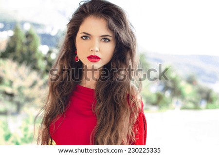 Beauty portrait of young attractive woman with red lips and long healthy wavy hair, outdoor photo.