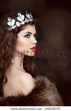 Fashion beautiful woman posing in fur coat. Winter Girl Model in Luxury clothes and furry hat Isolated on black background.