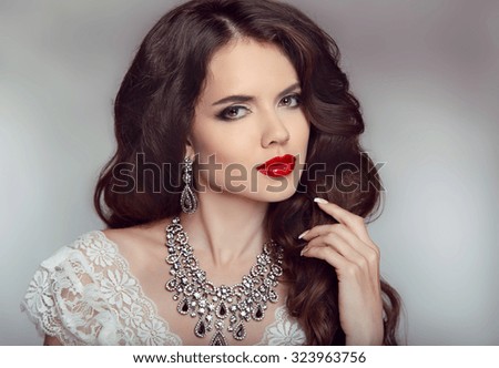 Portrait of a beautiful fashion bride girl with sensual red lips. Wedding make up and waving hair. Studio background. Luxury modern style.