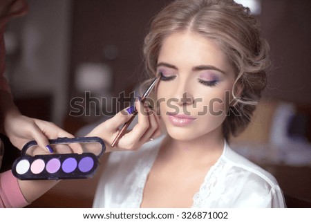 Beautiful bride wedding with makeup and hairstyle. Stylist makes make-up bride on wedding day. portrait of young woman at morning.