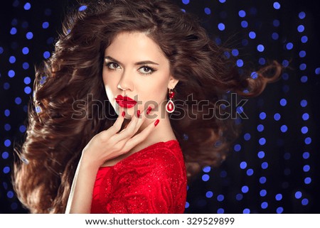 Long  hair. Beautiful brunette. Makeup. Luxury fashion style, manicure, cosmetics. Attractive young woman model posing on holiday blue lights background.