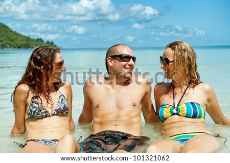 Group of girl and guy friends enjoying beautiful tropical vacation in the warm sunny Seychelle island oceans and palm trees