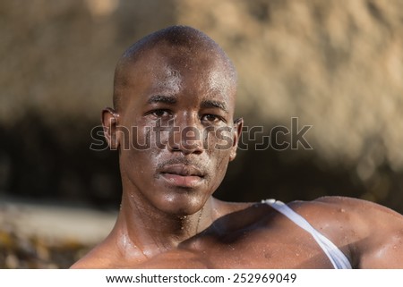 African black man, who is wet after washing his face with water. Portraying despair, worry, relief or cleanliness