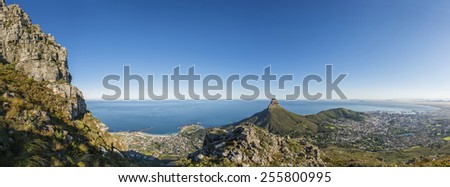 View from one of the many hiking routes up Cape Town\'s Table Mountain. Lions Head and Cape Town city in distance as sun rises over the city. Very popular daily activity for both locals and tourists.