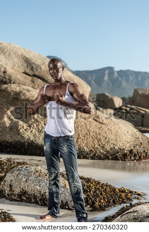 Black male model, ripping his white vest shirt