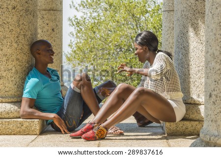 African couple sitting, having fun on date