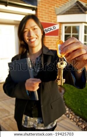 Female real-estate agent holding keys to a new property