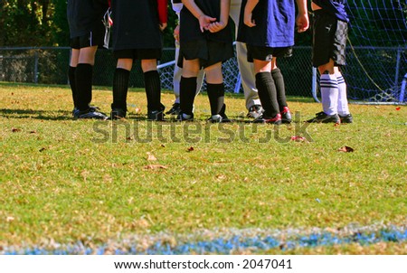 Kids\' soccer team in coach\'s huddle